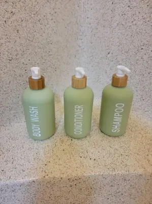 three green bottles sitting on a counter at Exotic Gem Relaxing Farm Vibes Near Safari Zoo, Legoland & Wineries in Escondido
