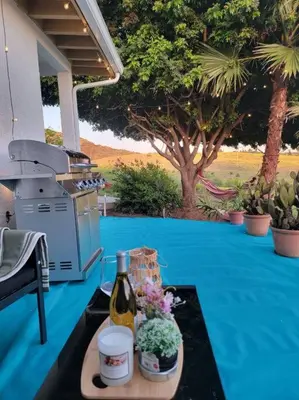 a table with a bottle of wine and flowers on it at Exotic Gem Relaxing Farm Vibes Near Safari Zoo, Legoland & Wineries in Escondido