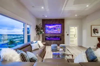 a living room with a couch and a large window at Lux Escape 2 • Views Hot Tub Games Mini Golf in San Diego