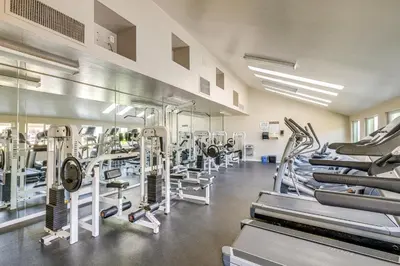 a gym with rows of treadmills and machines at San Diego Condo with Pool Access about 2 Mi to Beach! in San Diego