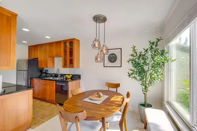 a kitchen with a wooden table and a dining room at San Diego Condo with Pool Access about 2 Mi to Beach! in San Diego