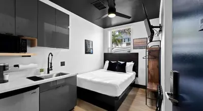 a small room with a bed and a sink in it at Balboa Park Hotel Downtown Little Italy in San Diego