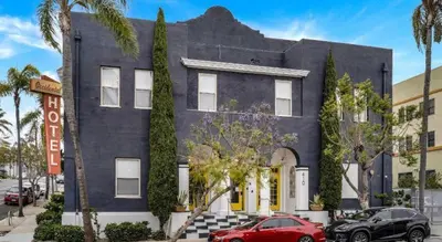 a blue house with cars parked in front of it at Balboa Park Hotel Downtown Little Italy in San Diego