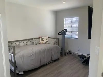 a bedroom with a bed and a lamp and a window at San Clemente Beach home walk to beach and downtown in San Clemente