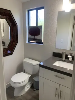 a bathroom with a toilet and a sink and a mirror at San Clemente Beach home walk to beach and downtown in San Clemente