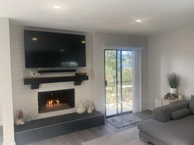 a living room with a fireplace with a tv above it at San Clemente Beach home walk to beach and downtown in San Clemente