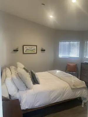 a bedroom with a bed with white sheets and pillows at San Clemente Beach home walk to beach and downtown in San Clemente