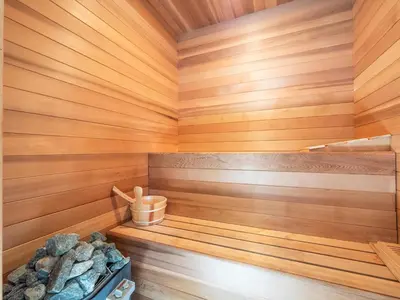 a sauna with wood paneling and a bucket of rocks at La Jolla Ocean Mansion in San Diego