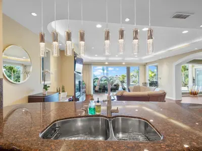 a kitchen with a sink and a living room at La Jolla Ocean Mansion in San Diego