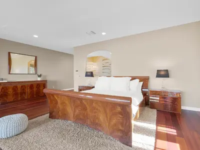 a bedroom with a large wooden bed and a mirror at La Jolla Ocean Mansion in San Diego