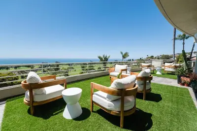 a row of chairs on a roof with the ocean in the background at La Jolla Ocean View Mansion 2 in San Diego