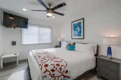 a bedroom with a bed and a ceiling fan at Mermaid's Penthouse in San Diego