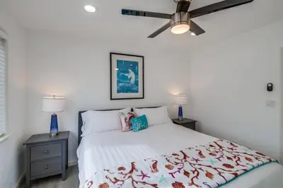 a bedroom with a white bed and two night stands at Mermaid's Penthouse in San Diego
