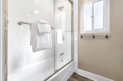 a bathroom with a shower with a glass door at Oceanfront Oasis in Newport Beach Steps to Balboa Park, Pier, and The Fun Zone! in Newport Beach
