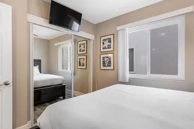 a bedroom with a white bed and a window at Beachside Oasis in Newport Beach Steps to Balboa Park, Pier, and The Fun Zone! in Newport Beach