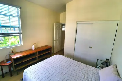 a bedroom with a bed and a desk and a window at Sweet Pea Place, 2 bed with pool in Encinitas