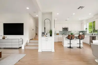 a kitchen with white cabinets and a flat screen tv at Makena By The Sea, 3 bed home near beach in Oceanside