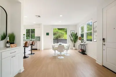 a white living room with a table and a piano at Makena By The Sea, 3 bed home near beach in Oceanside