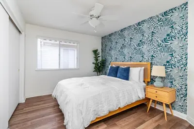 a bedroom with a bed with a blue accent wall at Sunset Views Retreat in Vista