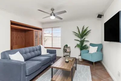 a living room with a blue couch and a tv at Sunset Views Retreat in Vista