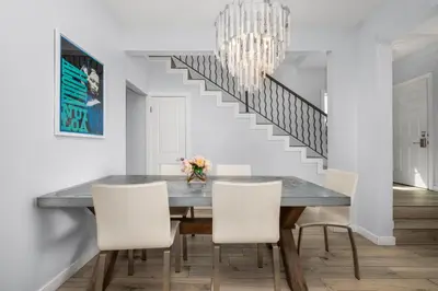 a dining room with a table and chairs and a chandelier at Stunning Casa Surf House in Newport with Parking Stunning Casa Surf House in Newport in Newport Beach
