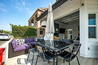 a patio with a table and chairs and an umbrella at Stunning Casa Surf House in Newport with Parking Stunning Casa Surf House in Newport in Newport Beach