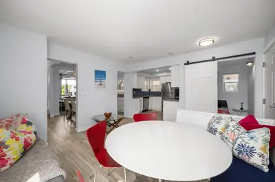 a kitchen and living room with a white table and chairs at Stunning Casa Surf House in Newport with Parking Stunning Casa Surf House in Newport in Newport Beach