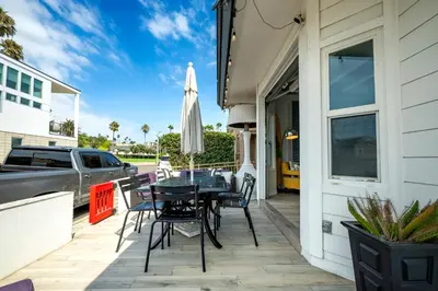 a patio with a table and chairs and an umbrella at Stunning Casa Surf House in Newport with Parking Stunning Casa Surf House in Newport in Newport Beach