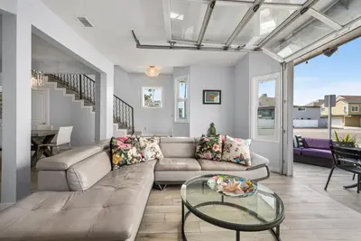 a living room with a couch and a glass table at Giant Newport Duplex - Surf, Sand, Playground, Parking in Newport Beach