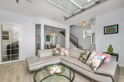 a living room with a couch and a glass table at Giant Newport Duplex - Surf, Sand, Playground, Parking in Newport Beach