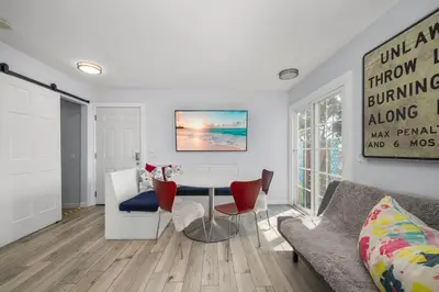 a living room with a table and a couch at Giant Newport Duplex - Surf, Sand, Playground, Parking in Newport Beach