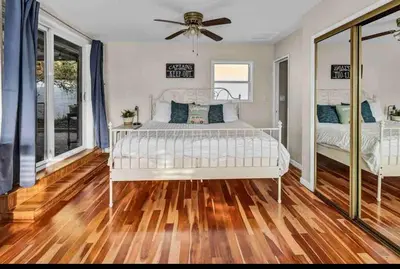 a bedroom with a white bed and a ceiling fan at Rustic Coastal Retreat in Sunset Cliffs three beds & two baths in San Diego