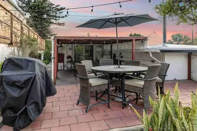a patio with a table and chairs and an umbrella at Rustic Coastal Retreat in Sunset Cliffs three beds & two baths in San Diego