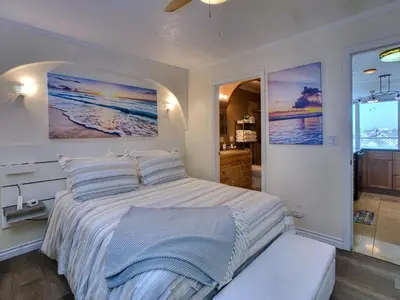 a bedroom with a large bed and a bathroom at Ocean, Bay, Downtown, and City view Condo, Few steps from the ocean in San Diego