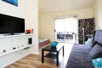 a living room with a couch and a flat screen tv at Studio Apartment with Pool in the Heart of MissionValley in San Diego