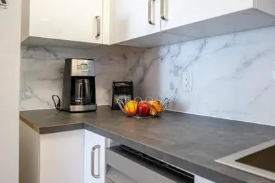 a kitchen with a bowl of fruit on a counter at Studio Apartment with Pool in the Heart of MissionValley in San Diego