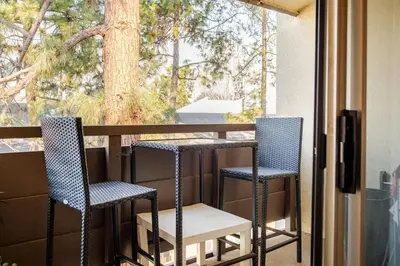 two chairs and a table on a balcony at Studio Apartment with Pool in the Heart of MissionValley in San Diego