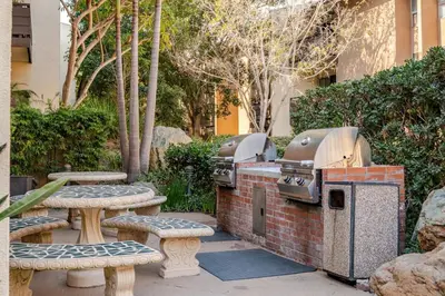 a patio with two bbqs and a grill and benches at Studio Apartment with Pool in the Heart of MissionValley in San Diego