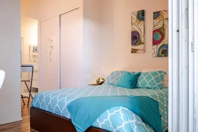 a bedroom with a bed with a blue comforter at Studio Apartment with Pool in the Heart of MissionValley in San Diego