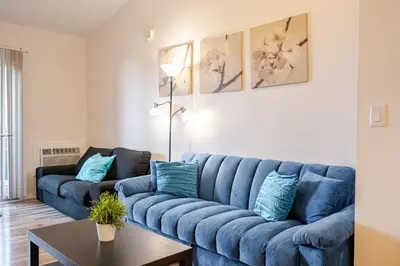 a blue couch in a living room with a table at Studio Apartment with Pool in the Heart of MissionValley in San Diego