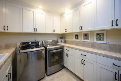 a kitchen with white cabinets and a dishwasher at 4BR Luxury Del Mar Beach House with Ocean Views in San Diego