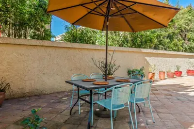 a table with chairs and an umbrella on a patio at La Jolla Gem condo in San Diego