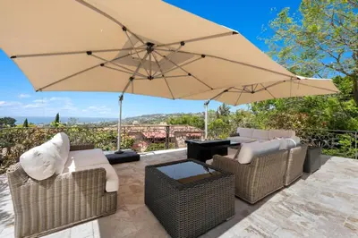 a patio with chairs and a large umbrella at Grand Mediterranean Villa in La Jolla Hillside in San Diego