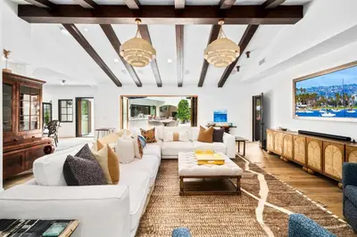 a living room with white furniture and a flat screen tv at Grand Mediterranean Villa in La Jolla Hillside in San Diego