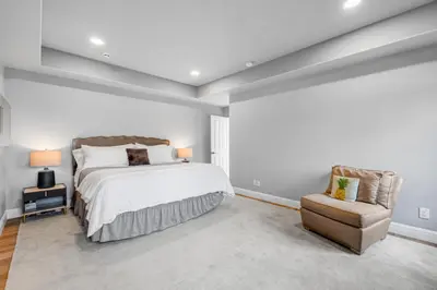 a bedroom with a large bed and a chair at Grand Mediterranean Villa in La Jolla Hillside in San Diego