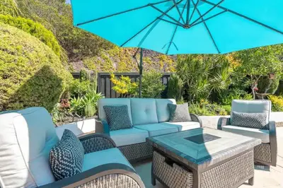 a patio with blue furniture and an umbrella at Designer Family Home with Resort-Style Oasis in San Diego