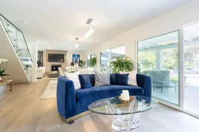 a living room with a blue couch and a glass table at Designer Family Home with Resort-Style Oasis in San Diego