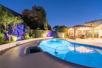 a swimming pool in a backyard at night at Designer Family Home with Resort-Style Oasis in San Diego
