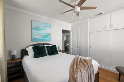 a bedroom with a white bed with a ceiling fan at Pacific Beach Gem Walk to Law Street Beach in San Diego
