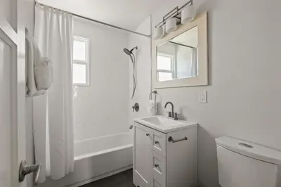 a white bathroom with a sink and a mirror at Pacific Beach Gem Walk to Law Street Beach in San Diego